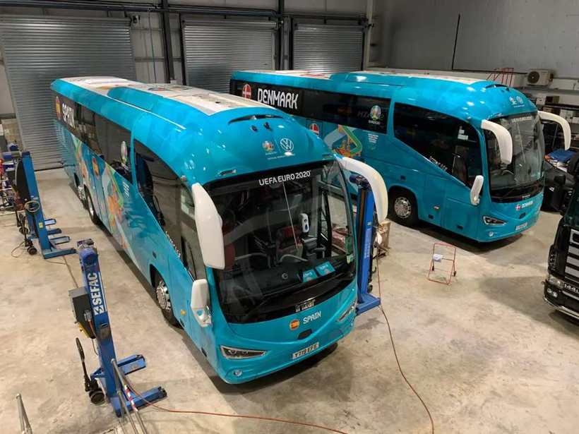 Turquoise team coaches being wrapped in the Wrap Cube unit